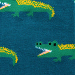 Close up pattern of green crocodiles on a dark green background