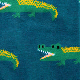 Close up pattern of green crocodiles on a dark green background