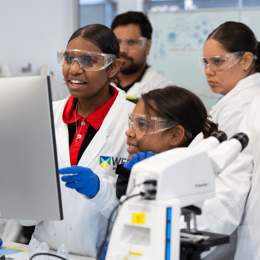 Deadly Pathways leaners in a lab setting with one using a computer and another looking at a microscope.