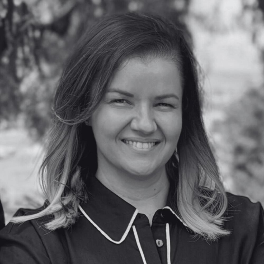 Black and white photo of Noongar/Wilman woman and Board member Katrina Byrne with a blurred natural background. 